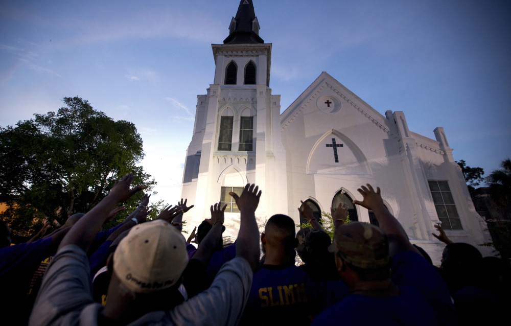 Members of the first international fraternal organization founded on a black campus, Omega Psi Phi, lead a prayer service outsie the Emanuel AME Church in Charleston, S.C., Friday, two days after the mass shooting.