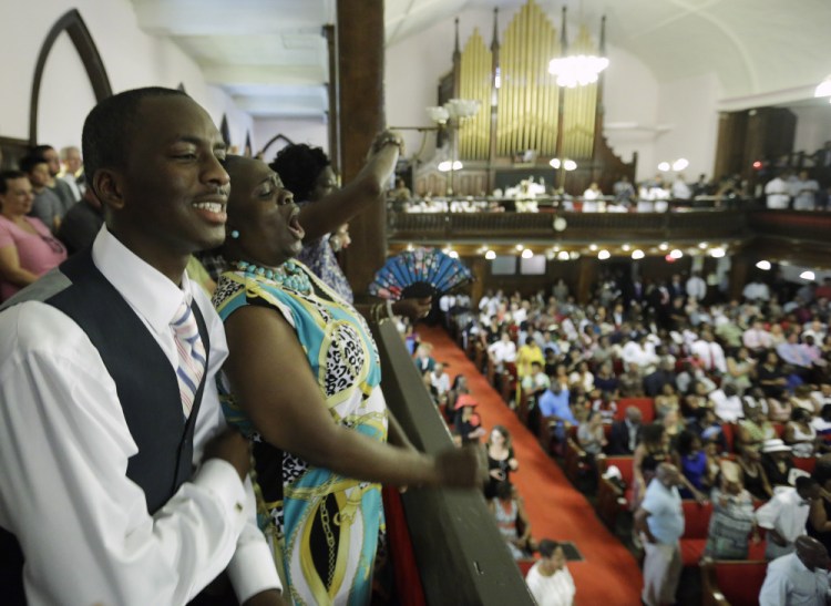 Parishioners Shakur Francis, left, and Karen Watson-Fleming sing at Sunday’s service in Emanuel AME Church in Charleston, S.C., four days after a mass shooting killed nine people during a Bible study there.