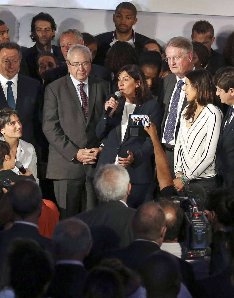 Paris Mayor Anne Hidalgo, center, announces the candidacy of Paris for the 2024 Olympics in Paris on Tuesday.