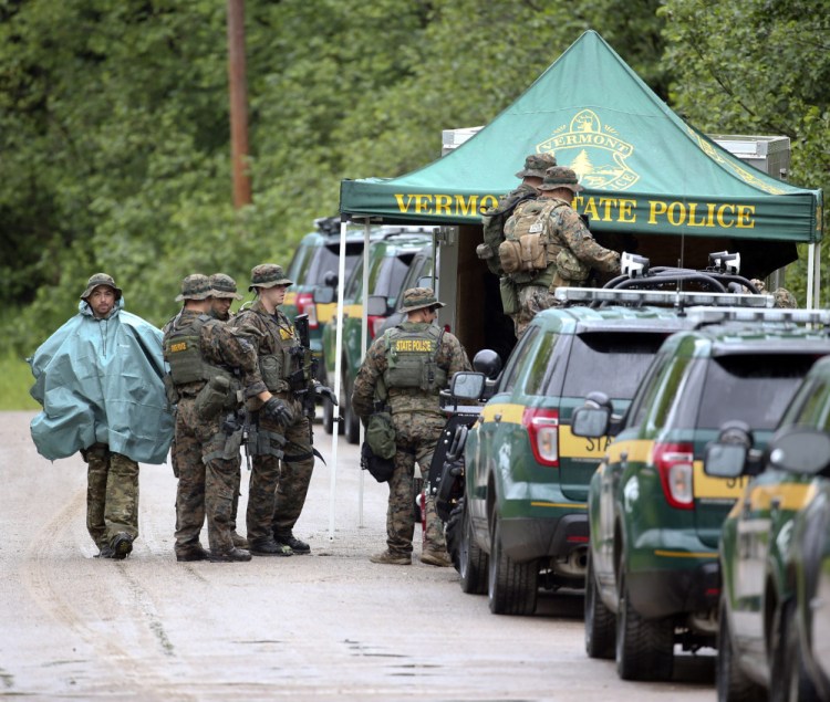 Law enforcement officers gather as the search continues for two escapees from Clinton Correctional Facility in Dannemora, on Tuesday, in Malone, N.Y.