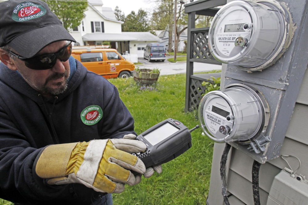 Mark Delbeck of Burlington Electric checks the radio frequency of a smart meter in Burlington, Vt. Home efficiency measures such as installing new windows or replacing insulation may actually cost homeowners money in the long run, according to the conclusion of a University of Chicago study.