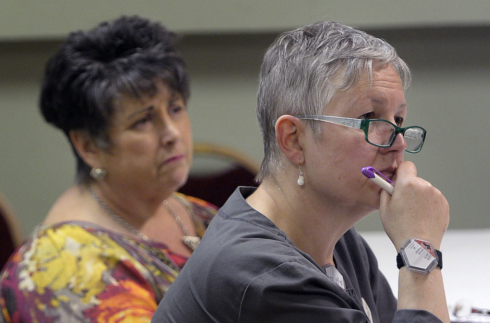 Tamlyn Osolin, left, of South Portland and Kathi Smith of Portland listens to Rev. Kenneth Lewis, pastor of Green Memorial A.M.E. Zion Church, Wednesday.
