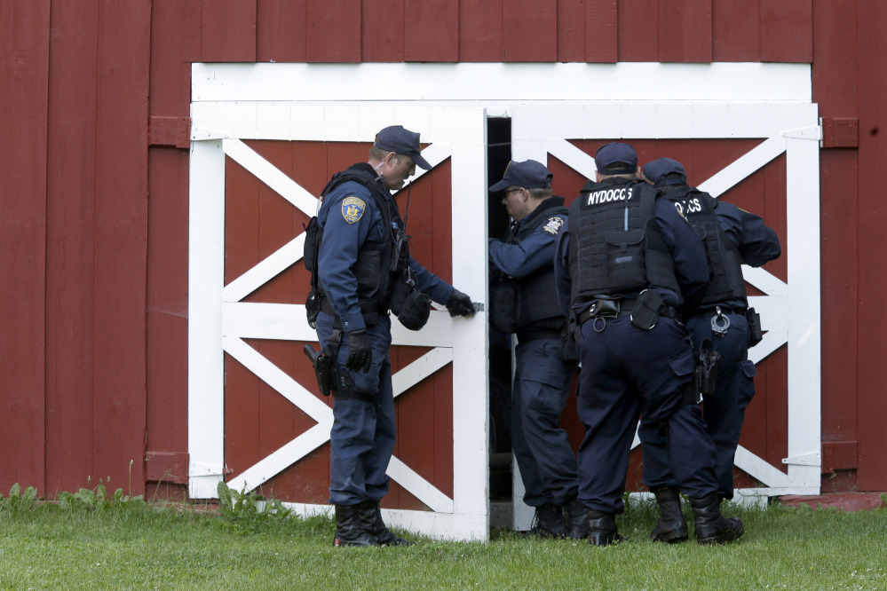 New York State Department of Corrections Officers search a barn in Owls Head, N.Y., for convicted murderers Richard Matt and David Sweat on Friday. Police shifted a focus of their three week search closer to the Canadian border.
