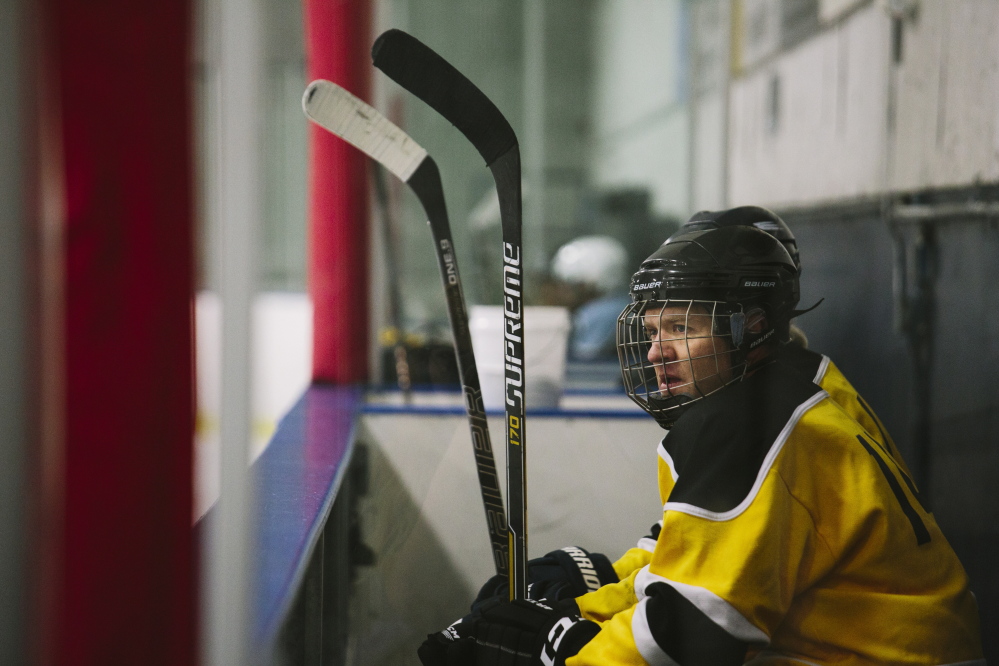 Gibson Fay-LeBlanc watches the action from the bench during a recent game at the Portland Ice Arena. He’s working on a collection of hockey-themed poems that will be called “Deke.”  Whitney Hayward/Staff Photographer