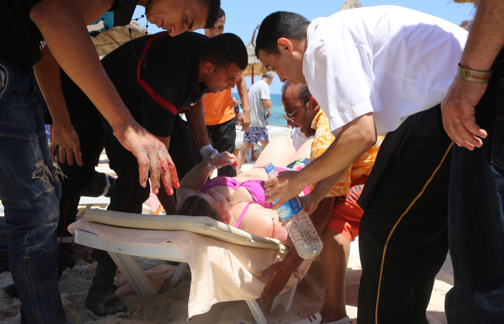 Injured people are treated on a Tunisian beach, in Sousse, on Friday, after a young man unfurled an umbrella and pulled out a Kalashnikov, opening fire on European sunbathers in an attack that killed at least 28 people there.