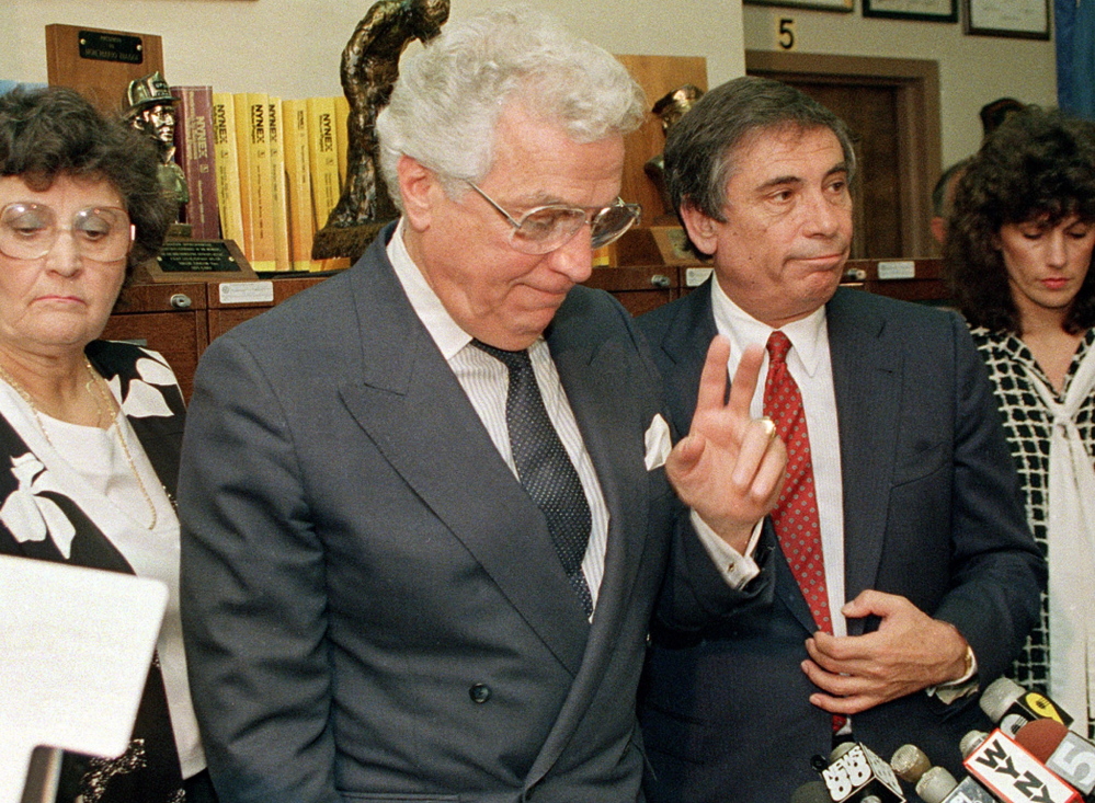 Mario Biaggi, second left, gestures to the media shortly after announcing his resignation from Congress on Aug. 8. 1988, at his headquarters in New York.
