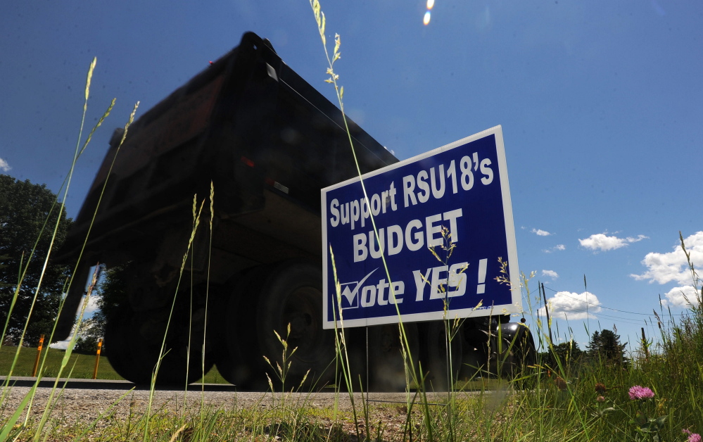 Parents in Regional School Unit 18 have put up signs urging a yes vote on the budget, which goes before voters in Oakland, Belgrade, China, Rome and Sidney on Tuesday. Voters rejected the original budget proposal in May.