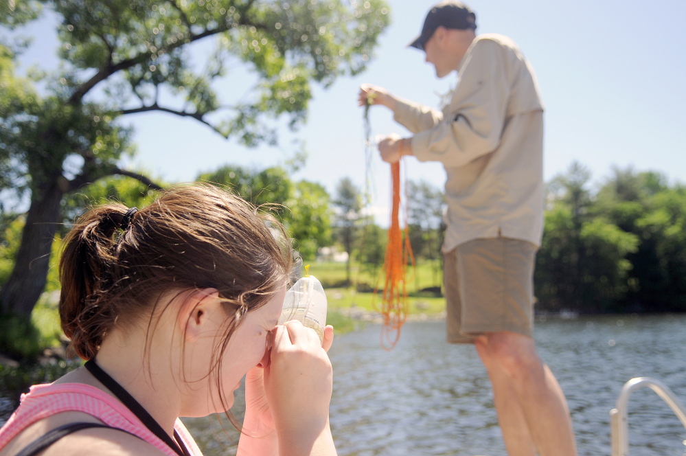 Amy Havens scrutinizes algae that Robin Sleith, right, collected Wednesday from the bottom of Minnehonk Lake in Mount Vernon.