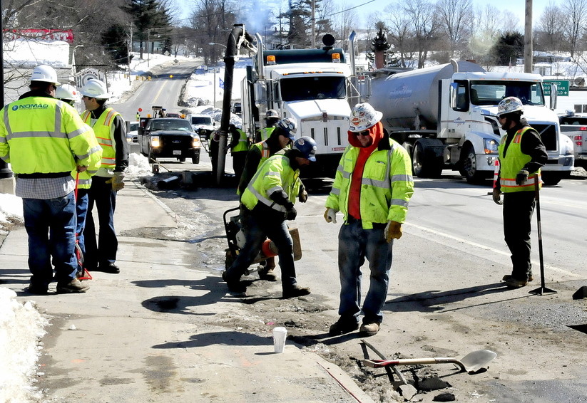 Employees of Summit Natural Gas of Maine and subcontractors work on the gas pipeline in the center of Norridgewock. The company is lowering its prices by 70 percent.