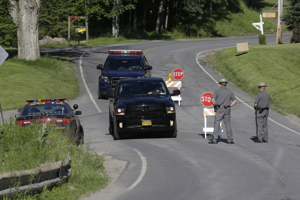 New York State officers stand at the road block at the perimeter of the search area for convicted murderer David Sweat on Saturday in Malone, N.Y.