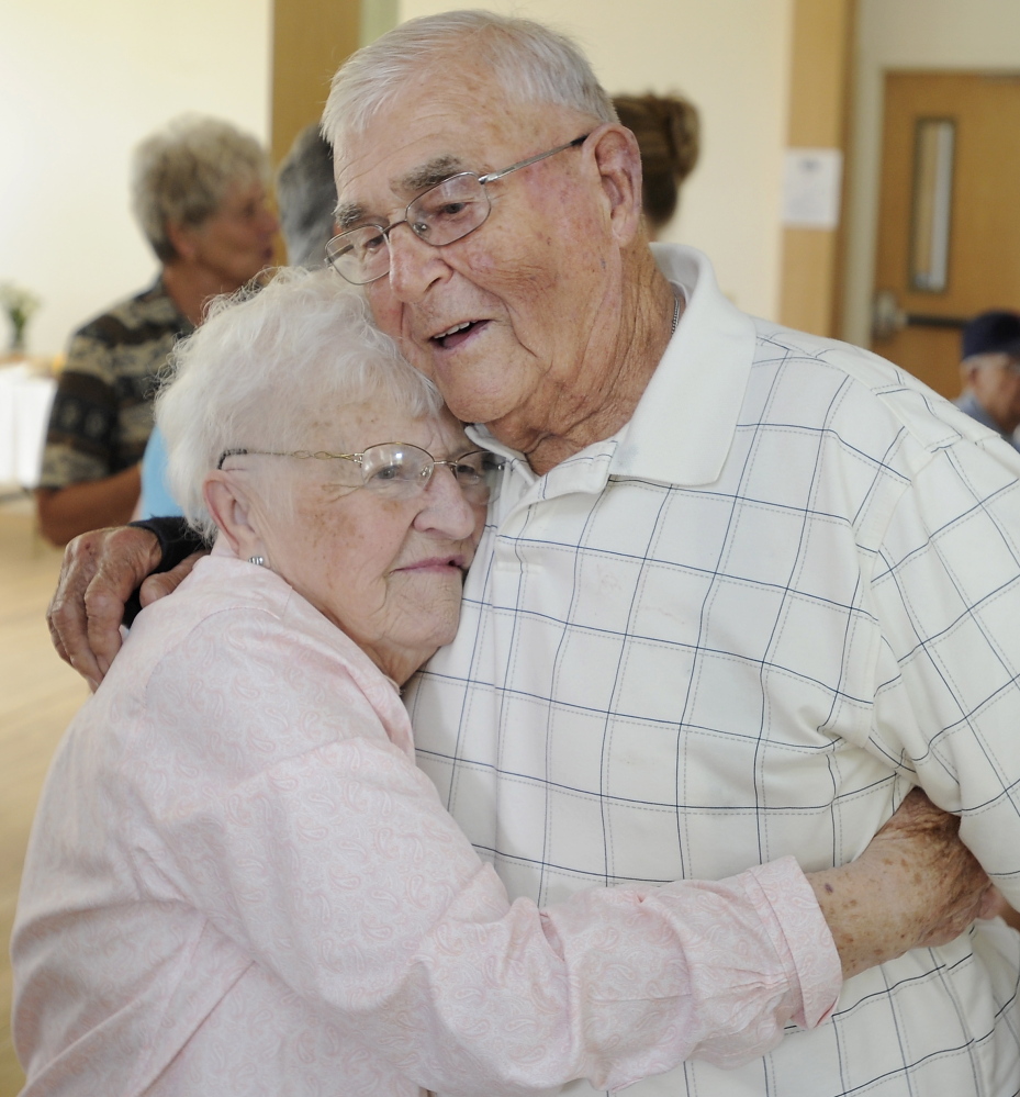 Oland Morton gets a big hug from his wife, Violet, as they celebrate their 70th wedding anniversary with family and friends in their hometown of Gorham.