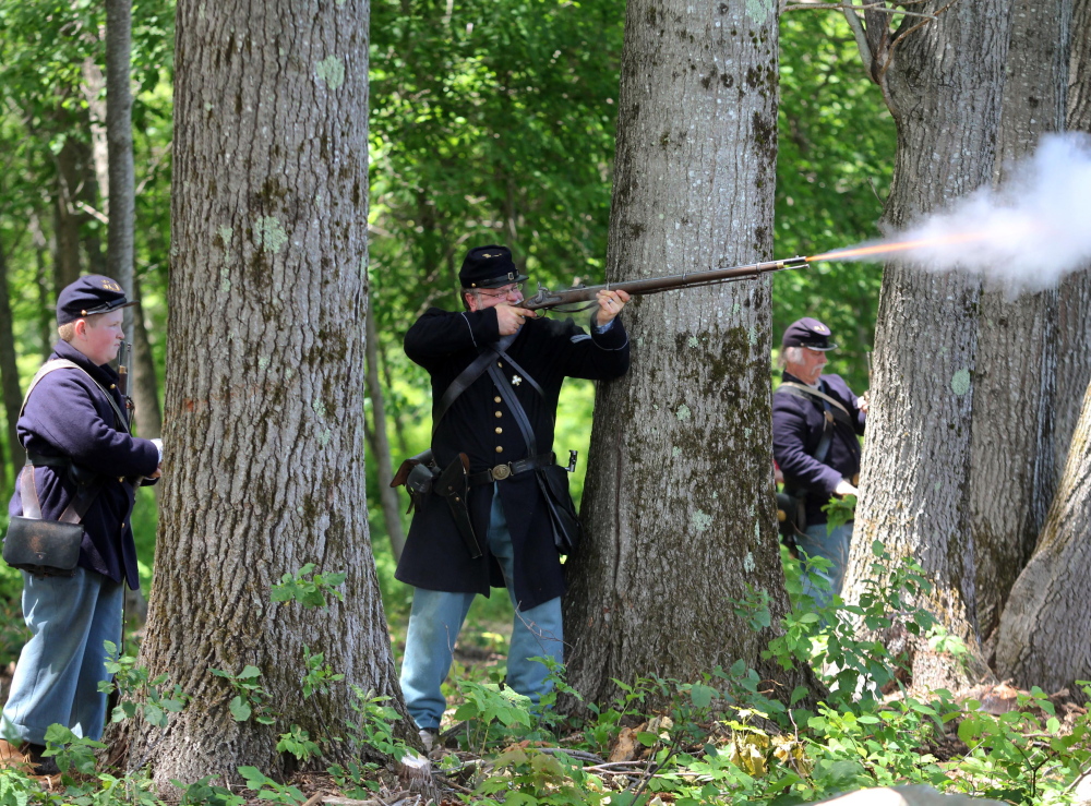 Tom Connell, of the 15th Massachusetts Volunteer Infantry re-enactment group, fires his musket at Confederate troops Saturday during a Civil War re-enactment at Viles Arboretum in Augusta.