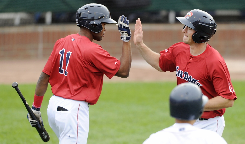 Jantzen Witte, right, gets a high-five from Manuel Margot after scoring the Sea Dogs’ first run. Witte led off the second inning with a triple and scored on a sacrifice fly by Sam Travis.