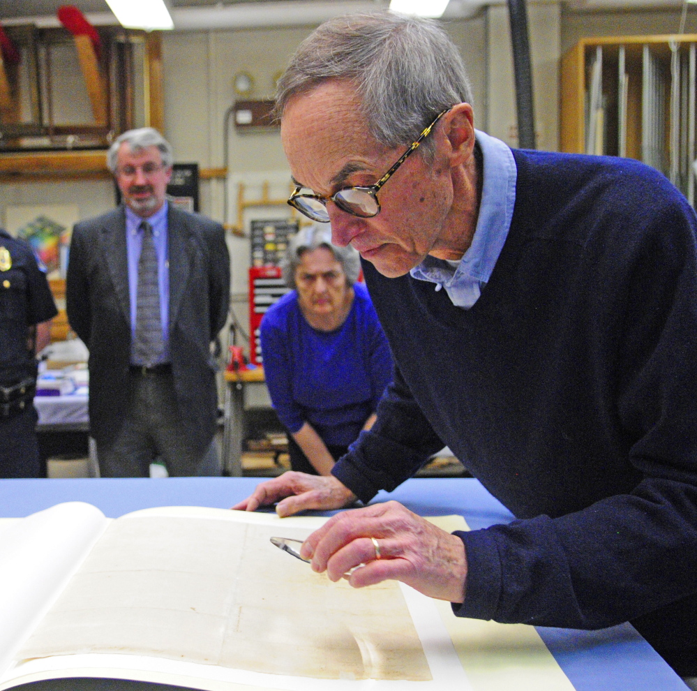 Sam Webber looks at the writing on the back of the city’s 1776 copy of the Declaration of Independence at the Maine State Museum in Augusta in April.