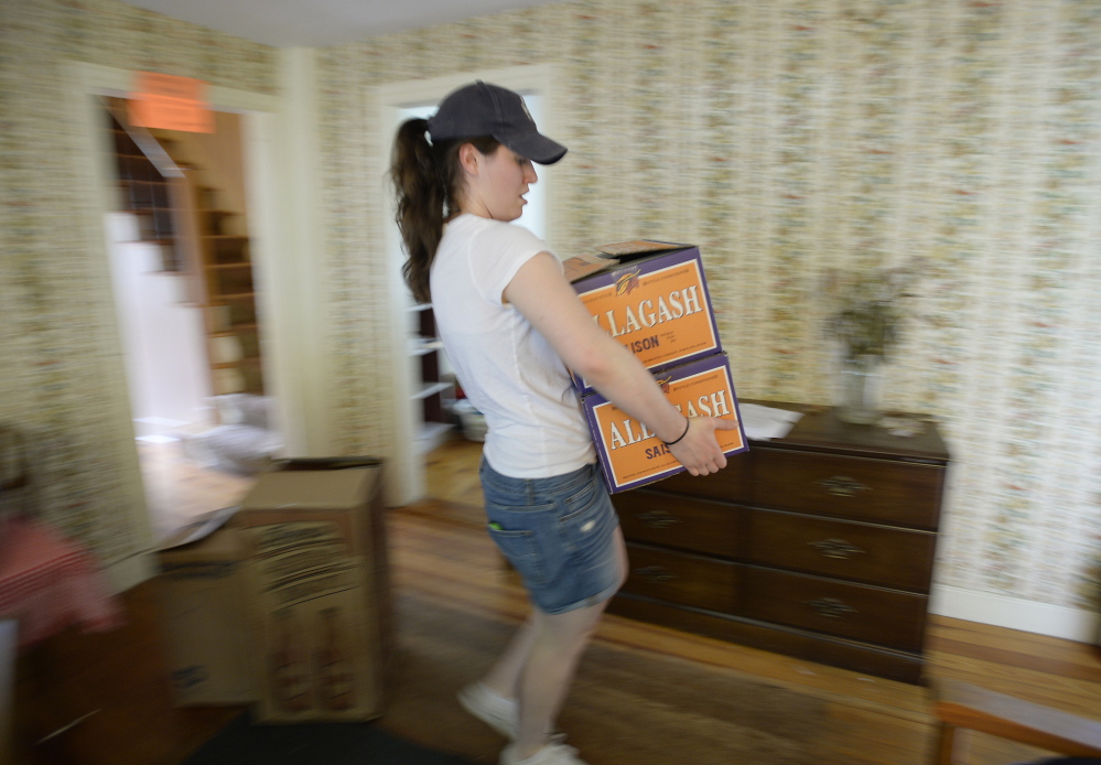 Caroline Ferguson carries boxes out of her Brunswick apartment. Saying goodbye to college was a gradual process for her and her housemates.