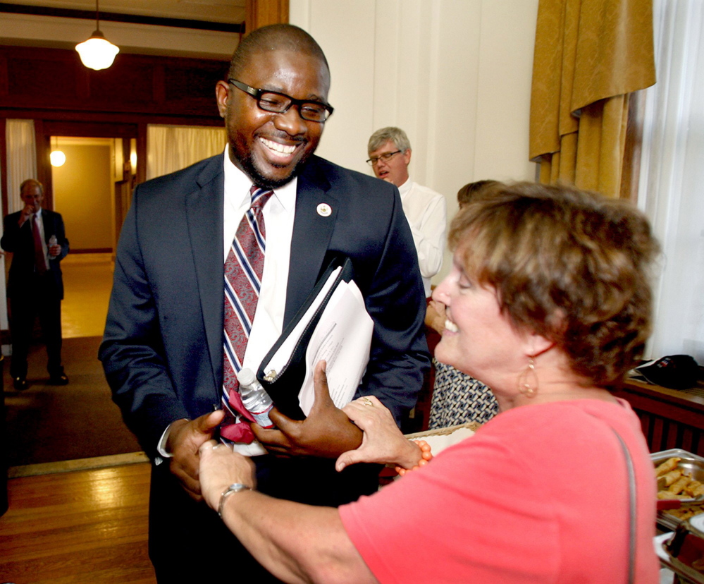 Emmanuel Caulk and teacher Joan Gildart share a laugh at a City Hall reception for Caulk in 2012 after the Portland School Board voted to name him the new superintendent.