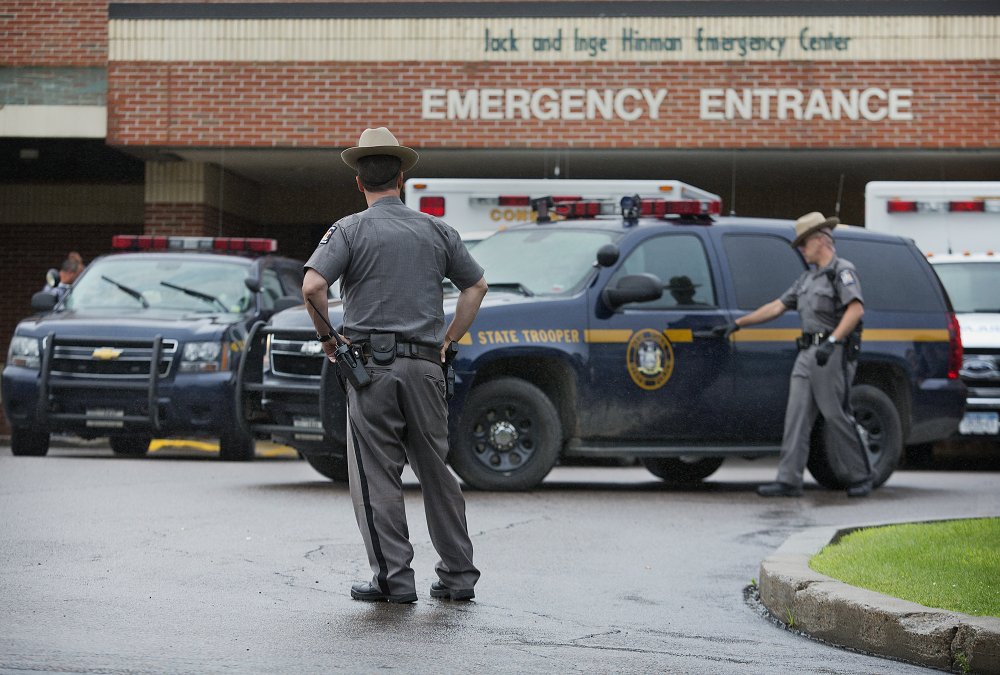 Law enforcement officers stands outside Alice Hyde Medical Center in Malone, N.Y., on Sunday, where David Sweat was taken initially after being shot and captured. He has since been tranferred to Albany Medical Center and his condition has improved.