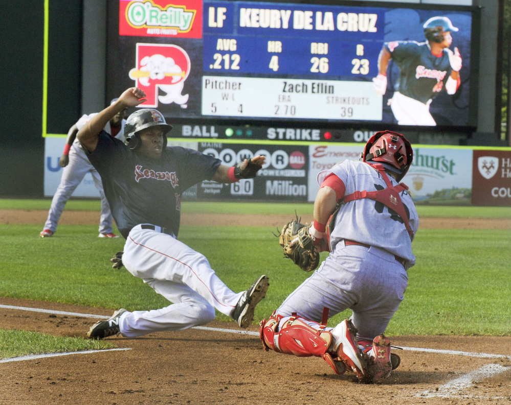 Manuel Margot slides into home safely as Reading catcher Andrew Knapp waits for the throw in the second inning of the Sea Dogs’ 5-4 win in the first game of a doubleheader Monday in Portland. Reading won the second game 6-1.