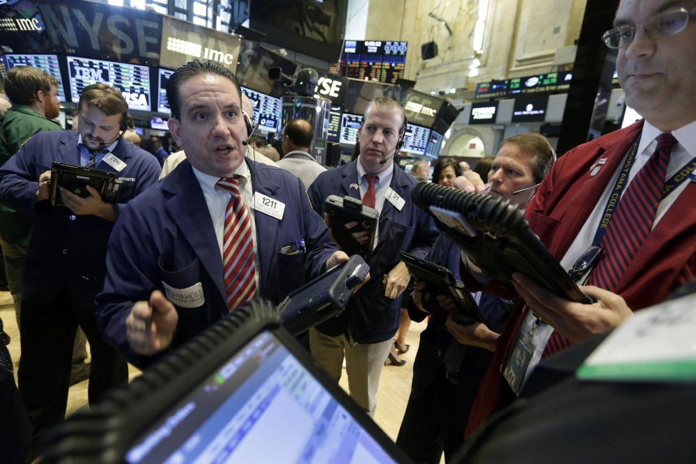 Tommy Kalikas, second left, works with fellow traders on the floor of the New York Stock Exchange on Tuesday.