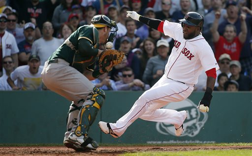 Red Sox DH David Ortiz scores on a single by Mike Napoli as Athletics catcher Stephen Vogt bobbles the throw in the third inning Saturday at Fenway Park. The Associated Press