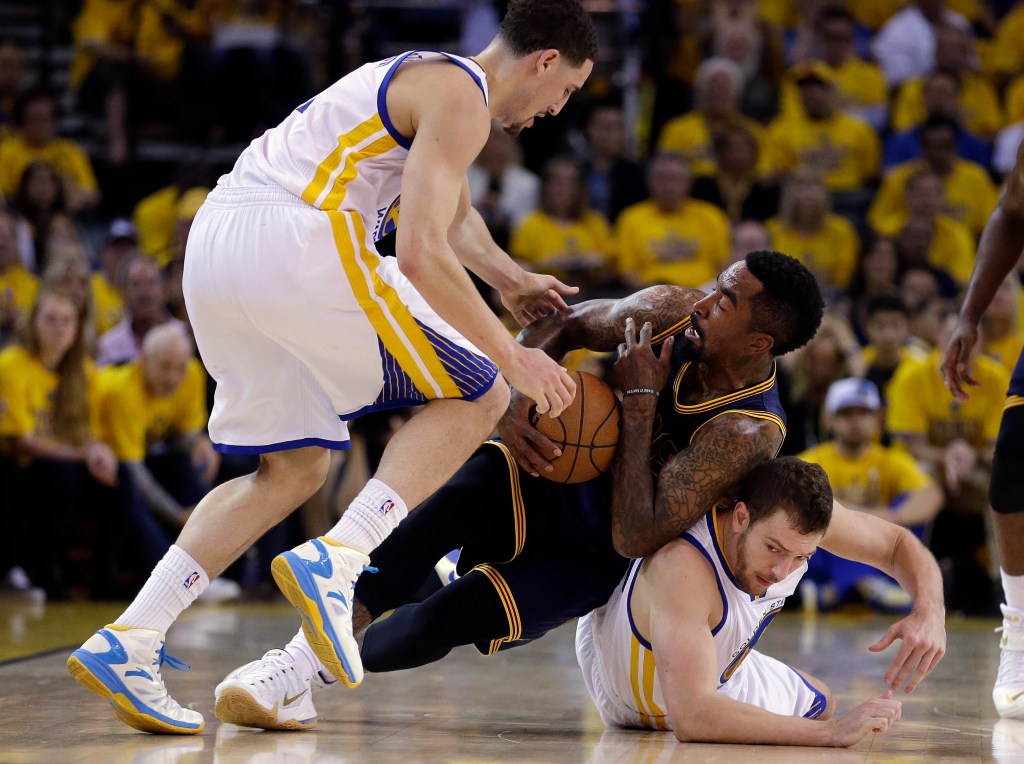 Cavaliers guard J.R. Smith falls on top of Golden State’s David Lee while Klay Thompson moves in to try to take the ball away. Golden State is one win away from its first NBA title since 1975 and can clinch the series Tuesday night. The Associated Press