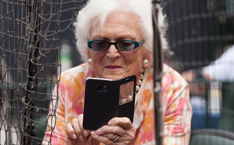 Former first lady Barbara Bush takes photos with her cellphone before  a Houston Astros game in Houston in this May 3, 2015, photo. 