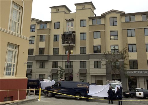 Police and officials stand outside of the Library Gardens apartment complex, where a fourth floor balcony rests on the balcony below after collapsing early Tuesday morning near the University of California, Berkeley. The Associated Press