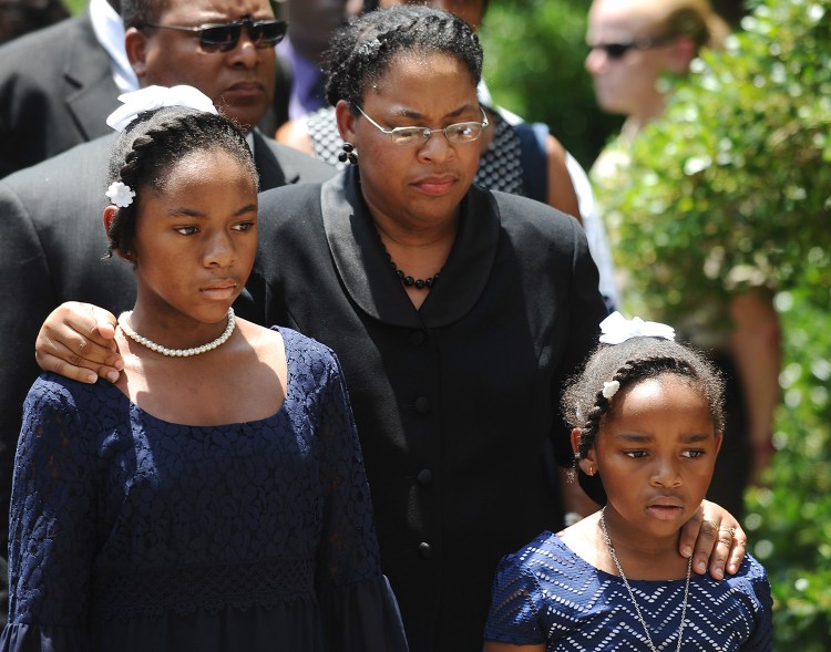 Sen. Clementa Pinckney's wife Jennifer Pinckney, center, and her daughters, Eliana, left, and Malana, right, follow his casket into the South Carolina Statehouse on Wednesday in Columbia, S.C. Pinckney's open coffin was put on display under the dome where he served the state for nearly 20 years. 