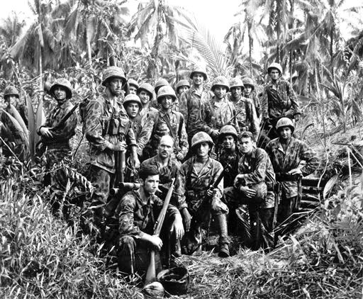 This January, 1944,  photo shows U.S. Marine Raiders posing in front of a Japanese stronghold they conquered at Cape Totkina, Bougainville, in the Solomon Islands. The Associated Press