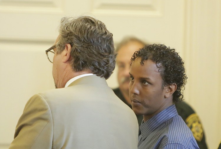 Mohamud Mohamed looks to his attorney, Thomas Hallett, during Mohamed's arraignment at York County Superior Court in Alfred on Friday. He pleaded not guilty to charges of murder and conspiracy in the death of Charles Raybine in 2013. 