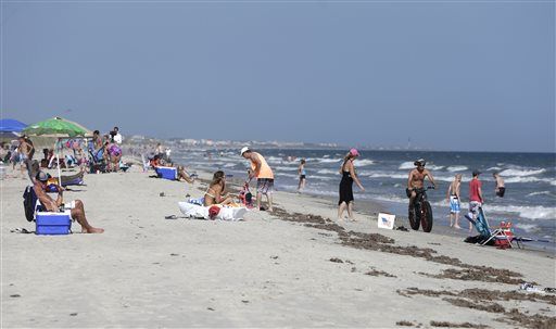 Vacationers relax on the beach and in the surf in Oak Island, N.C., Monday following Sunday's shark attacks that severely injured two people within an hour and about  2 miles from each other. The Associated Press