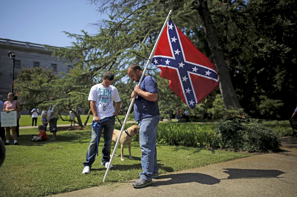 A man, who declined to give his name, holds a Confederate flag during a rally outside the South Carolina Statehouse on Tuesday. Lawmakers planned to introduce a resolution to begin a debate on removing the Confederate flag from the Statehouse grounds. Reuters
