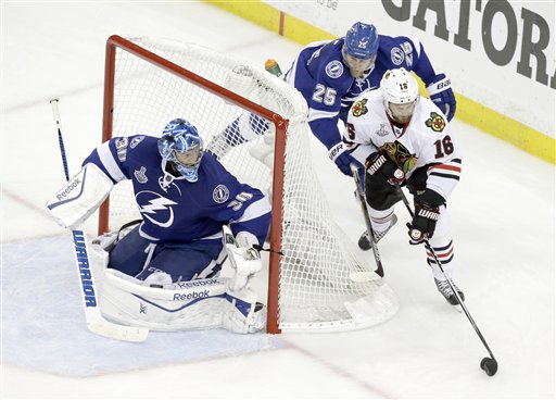 Chicago Blackhawks center Marcus Kruger wraps the puck around the goal in an attempt to score against Tampa Bay Lightning goalie Ben Bishop as Matt Carle helps defend in the third period of Game 5 of the Stanley Cup finals on Saturday in Tampa, Fla. The Associated Press