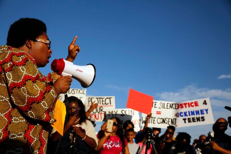 Olinka Green, founder of No Longer Invisible, leads a protest at Joyce Kelley Comstock Elementary School on, Monday before marching to the Craig Ranch pool where McKinney Police Cpl. Eric Casebolt was  seen on video pinning an African-American girl to the ground and pointing his gun at other teenagers.The Dallas Morning News via AP