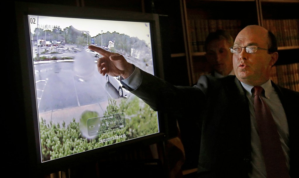 First Assistant Suffolk County District Attorney Patrick Haggan points to surveillance video released during a news conference Monday in Boston, which shows the fatal shooting of a Boston man suspected of plotting to kill police officers. The video comes from a restaurant across the street, and the figures shown are blurry. 
The Associated Press