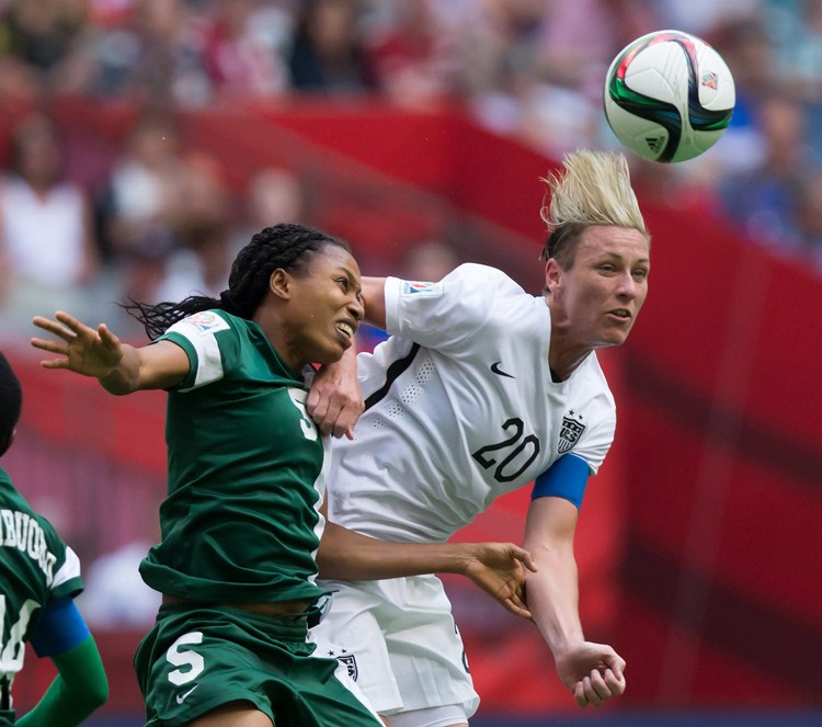 Nigeria's Onome Ebi, left, and United States' Abby Wambach vie for the ball during the second half of a FIFA Women's World Cup soccer game Tuesday  in Vancouver, British Columbia, Canada. The Associated Press