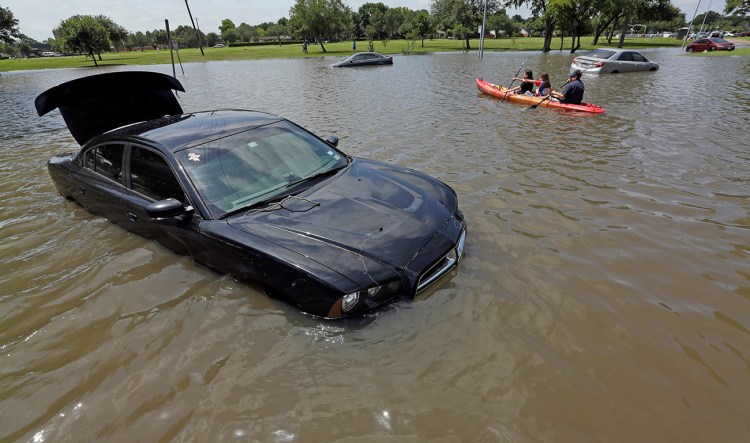 A boat floats down a flooded street in Houston in this May 26 photo. A NOAA climate scientist calculates that more than 200 trillion gallons of water fell on the contiguous U.S. in May. The Associated Press