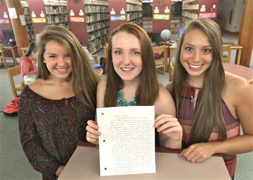High school students Mollykate Rodenbush, left, Brittany Tainsh and Michaela Arguin hold a letter from former Boston crime boss James "Whitey" Bulger in Lakeville, Mass. The three Apponequet Regional High School students wrote to Bulger for a history contest on leadership and got a surprising letter back. David L Ryan/The Boston Globe via AP