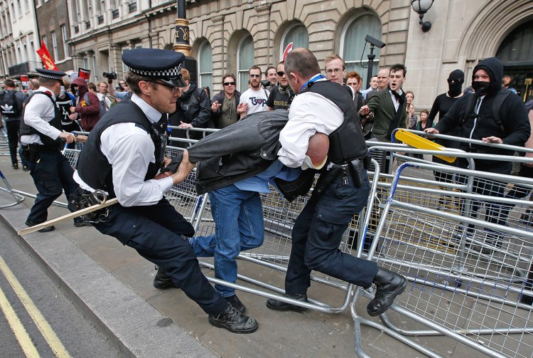 Police officers grapple with a demonstrator during protest outside Parliament in central London on  May 27, 2015. As increasingly horrified British officers and commanders have watched videos of American cops firing on civilians, they say they hope that some of their strategies and practices can be translated across the Atlantic. Reuters