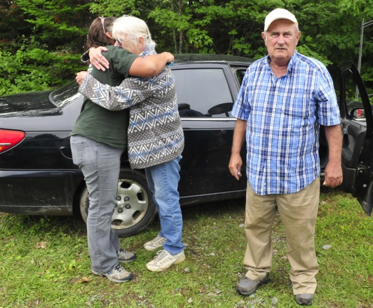 Floyd Richards watches firefighters put out a blaze that destroyed the home of his brother Bud and his wife, Paula, in Winslow. Kelly Klaiber, left, hugs her mother at the scene. 
Morning Sentinel photo