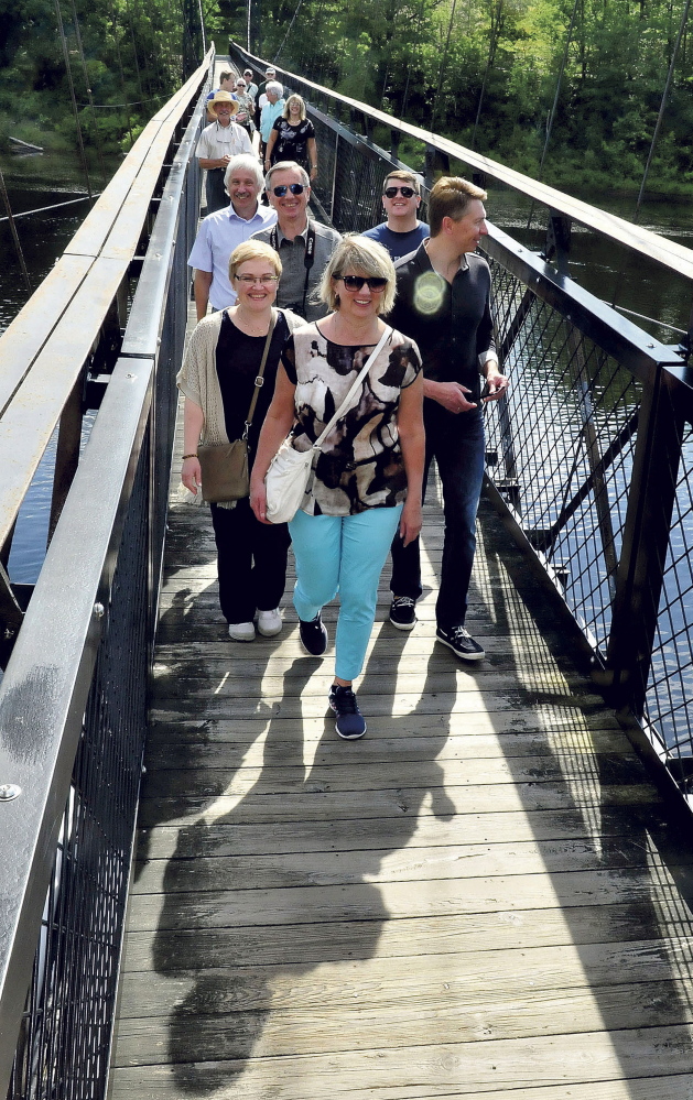 A group from Kotlas, Russia, sister city to Waterville, crosses the Two-Cent Bridge during their tour of the city Tuesday. The group arrived Friday and will leave later this week.