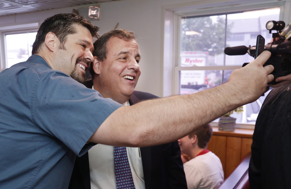 New Jersey Gov. Chris Christie poses for a selfie with a Becky’s Diner patron. Christie said Wednesday the endorsement by Gov. Paul LePage is the first by a sitting Republican governor for any of the party’s White House hopefuls.