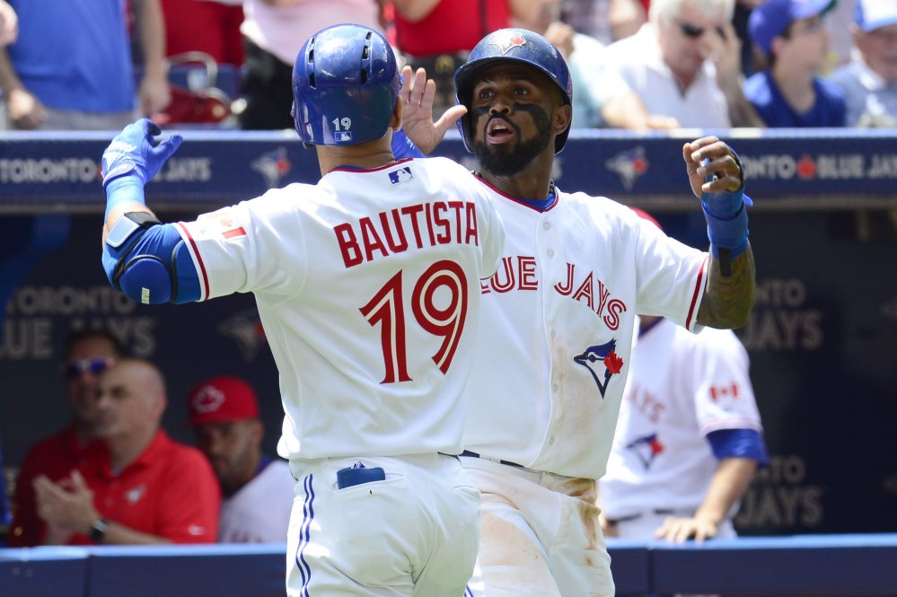 Jose Bautista is congratulated by teammate Toronto  Jose Reyes after hitting a two-run home run against the Boston Red Sox during the second inning of a baseball game in Toronto on Wednesday, July 1, 2015.