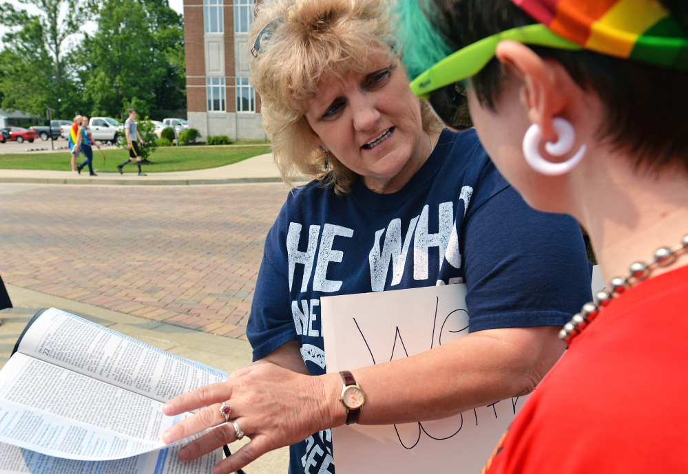 The Supreme Court’s ruling on gay marriage notwithstanding, opposition continues, including in Kentucky where Malinda Andrews refers to the Bible during a discussion with Erica Seagraves at the Rowan County Judicial Center on Tuesday.