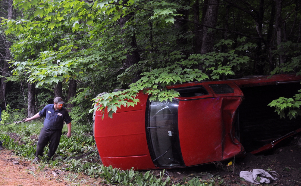 A winch is attached to a pickup that struck a tree and rolled over on Hallowell-Litchfield Road in Litchfield on Wednesday. The driver is charged with drunken driving and marijuana cultivation.