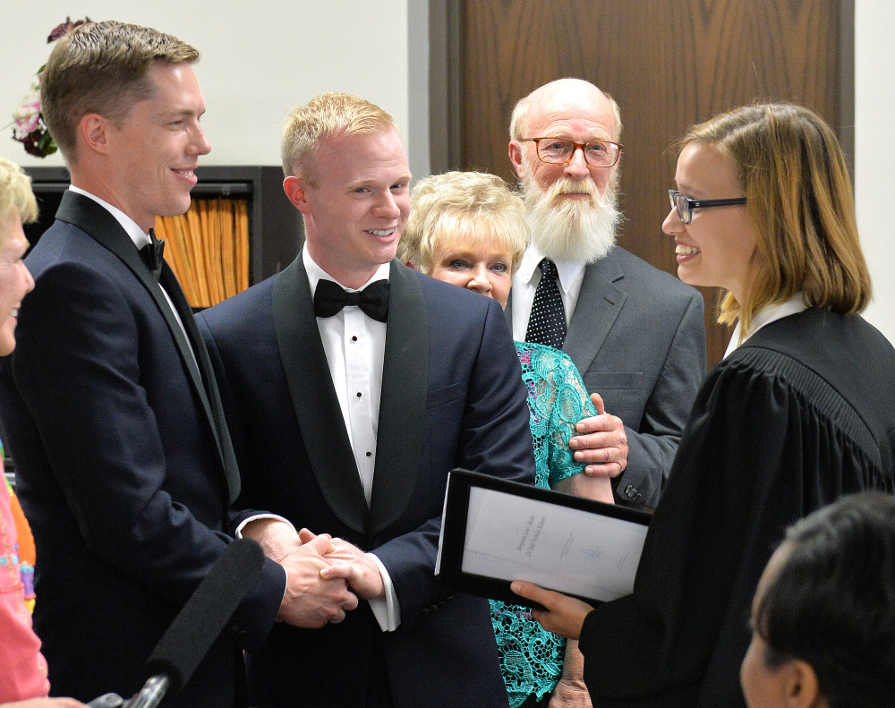 The Rev. Laura Barclay, right, officiates the marriage of Tadd Roberts, left, and Benjamin Moore at the Jefferson County Clerk's Office in Louisville, Ky.