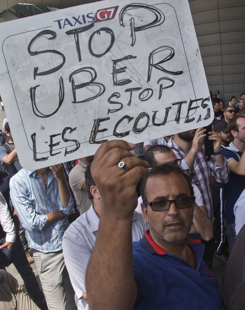 A striking taxi driver holds a placard reading “Stop Uber, Stop listening,” referring to the latest U.S. spying report in France, during a taxi driver demonstration in Paris on June 25. 