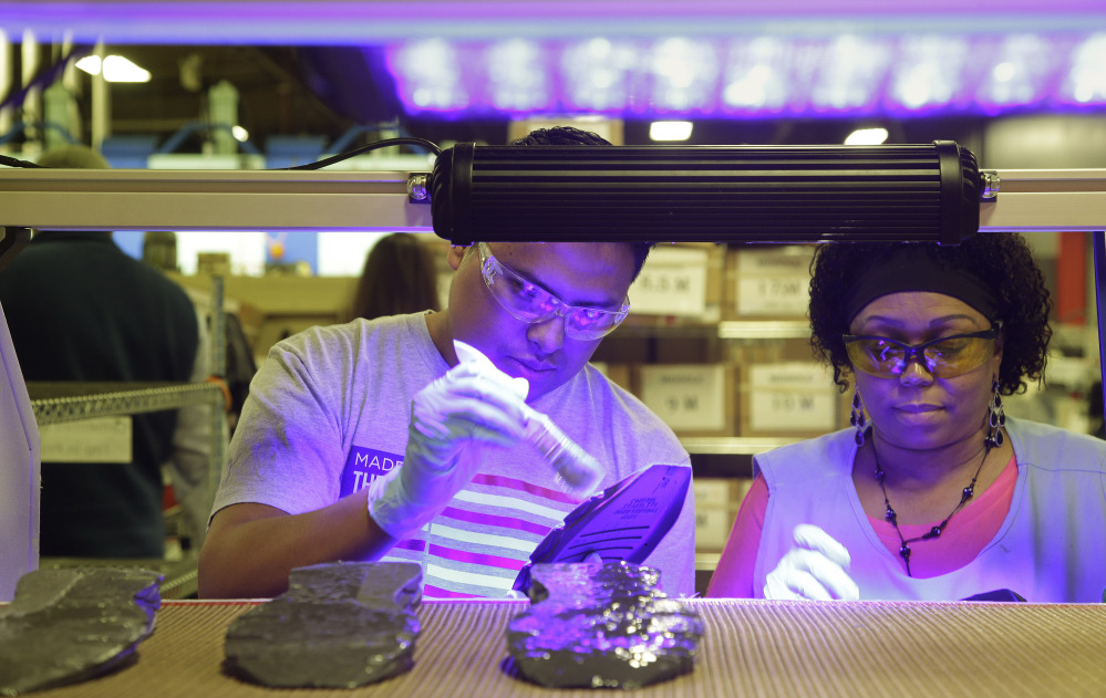 Under ultraviolet light, workers assemble the New Balance 950v2 sneaker in the company’s plant in Boston. A year after the commitment was made, New Balance is pressing the Pentagon to buy American-made footwear for the troops.