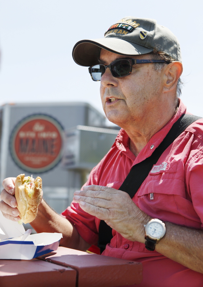 Joe Dube samples a McDonald's lobster roll Thursday at Fort Williams Park in Cape Elizabeth. Joel Page/Staff Photographer