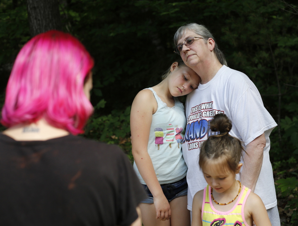 Jody Ingman comforts her granddaughter Delaney Walker, 10, at a Standish home that was the target of a hoax called swatting. 
Derek Davis/Staff Photographer